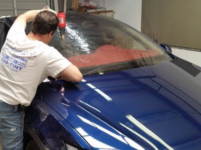 blue car being window tinted